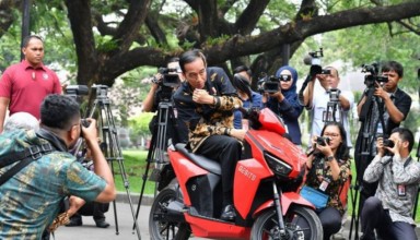 President Joko "Jokowi" Widodo poses on an electric motorcycle