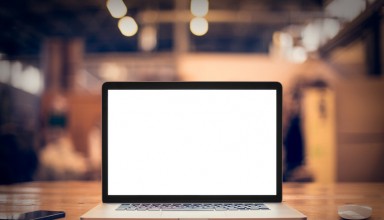 Laptop with blank screen on table