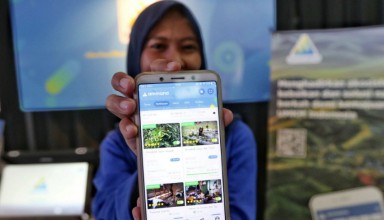 A woman shows fintech application Ammana on her smartphone