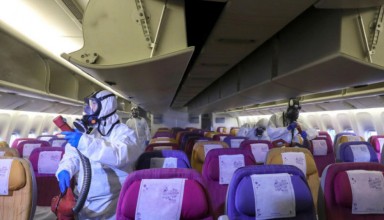 Members of a Thai Airways crew disinfect the cabin of an aircraft