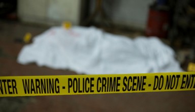 Crime scene band and covered dead body in background