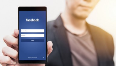 man show Facebook login page on his smartphone for using phone social app