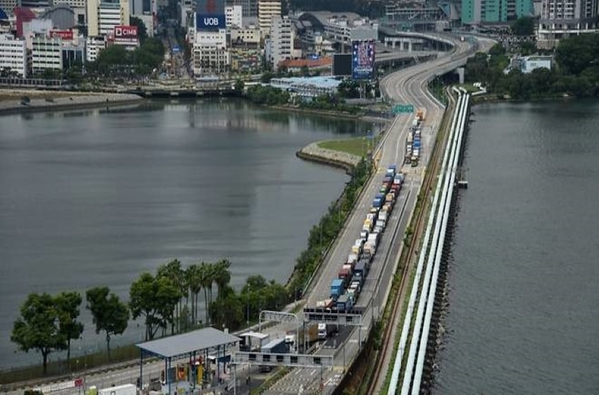On the 1st day of mandatory COVID-19 exams, several Malaysian cargo drivers are delayed at Singapore checkpoints.
