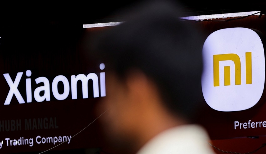 a man walks past a logo of xiaomi, a chinese manufacturer of consumer electronics, outside a shop in mumbai